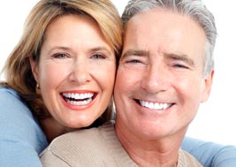 Uśmiechnięta kobieta i mężczyzna ze zdrowymi zębami - po leczeniu ortodontycznym i stomatologii estetycznej